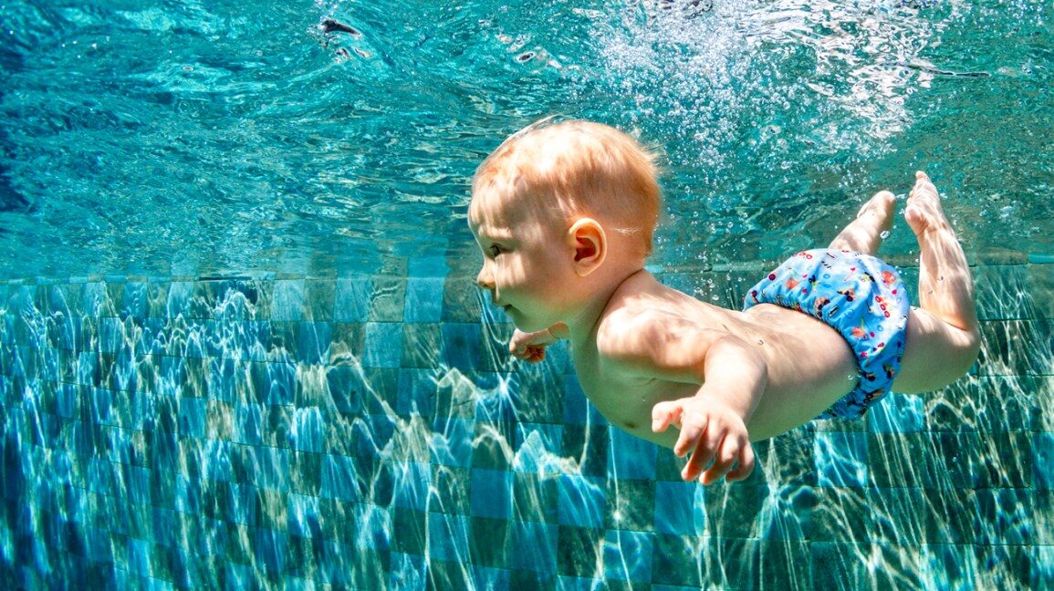 Bambino piccolo che nuota sott’acqua