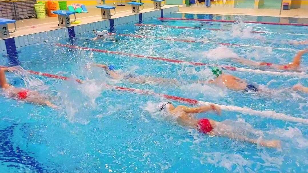 Giovani atleti della squadra agonistica in allenamento a dorso nelle corsie